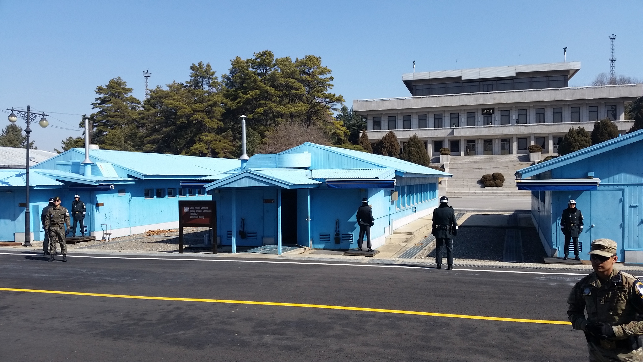 Building T-2, centered, at Panmunjom. Buildings T-1, T-2, and T-3 are visible in the picture as blue buildings in the foreground. In the background is North Korea's large building at Panmunjom.